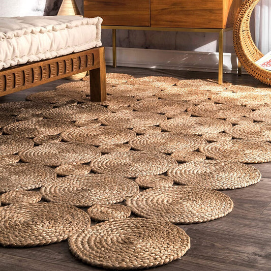 Woven jute rug on a wooden floor with a bed and mirror in the background