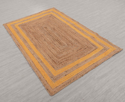 Rectangular jute rug with a yellow border on a gray floor.