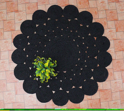 Black circular rug with a central plant on a tiled floor