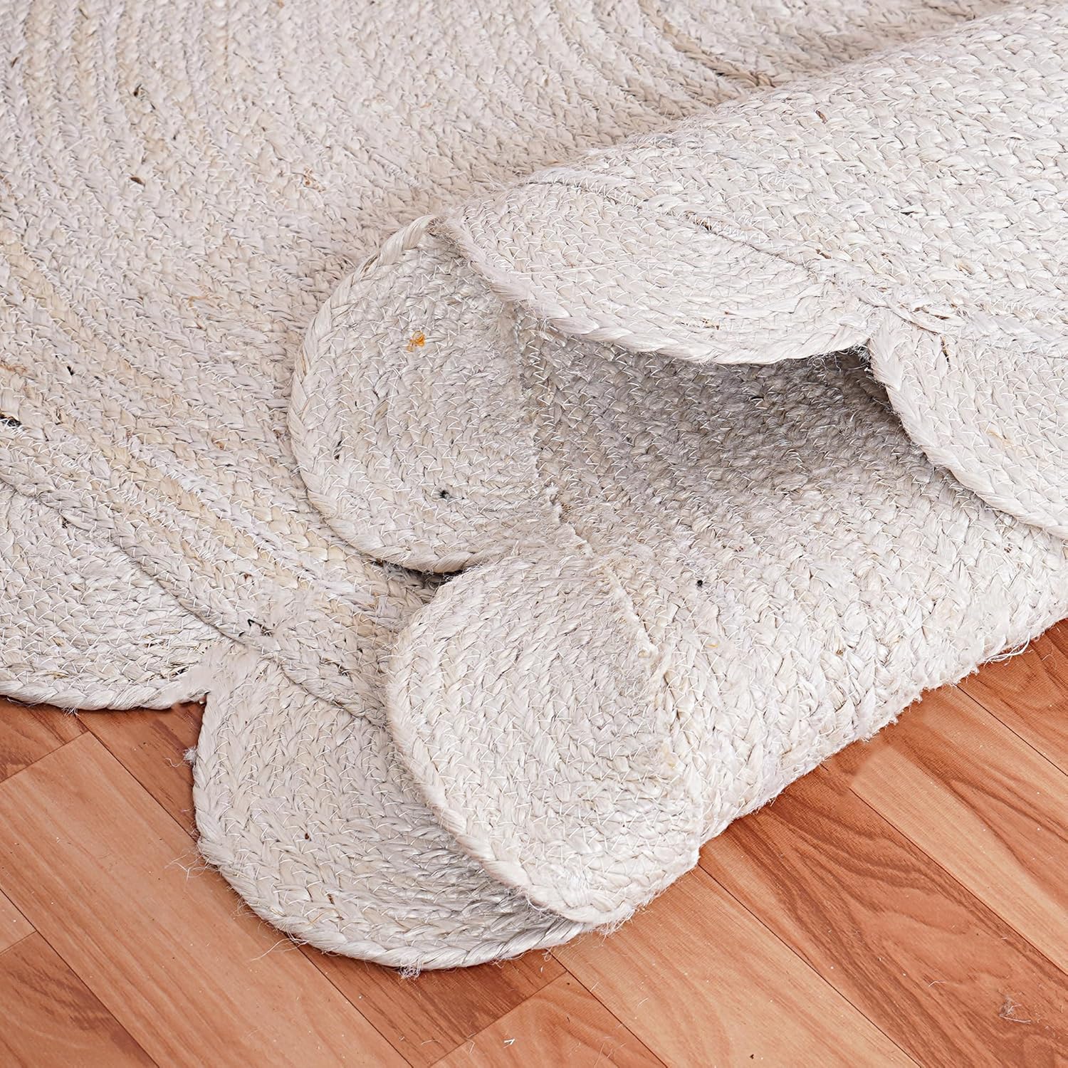 Close-up of beige braided rug on a wooden floor