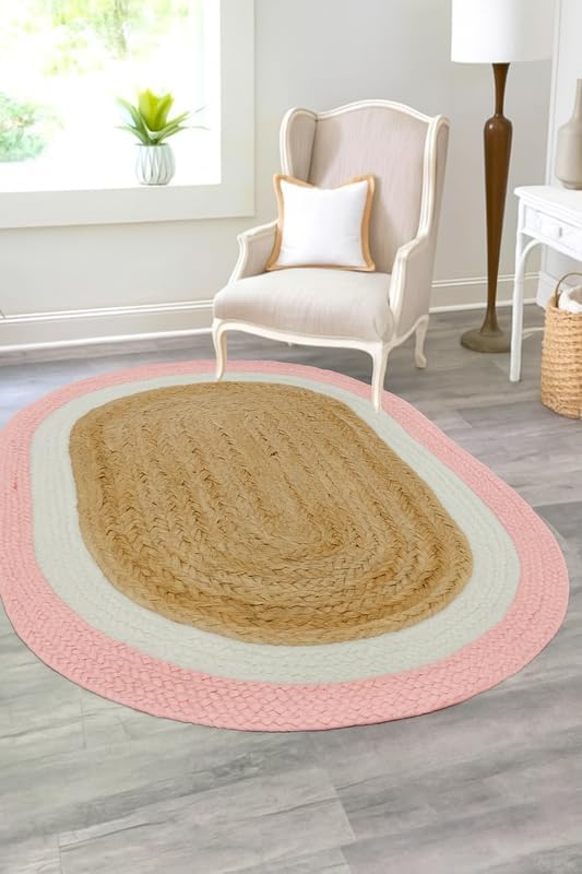 Braided oval rug in beige and pink, made of natural fibers, perfect for stylish home decor.