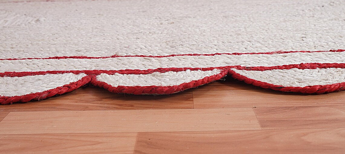 Close-up of a textured red and white rug on a wooden floor
