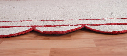 Close-up of a textured red and white rug on a wooden floor