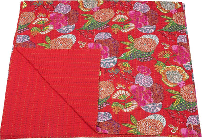 Red floral patterned quilt on a white background