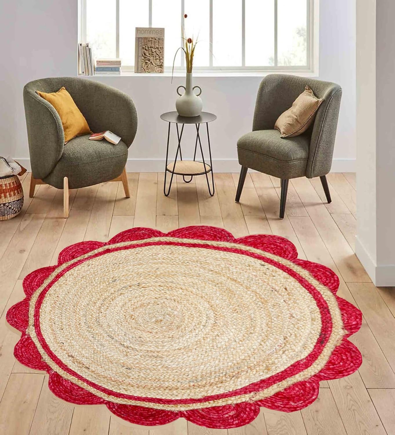 Round jute rug with red border on a wooden floor in a room with chairs and a small table.