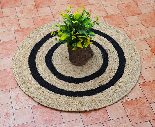 Round woven mat with concentric circles and a potted plant on a tiled floor