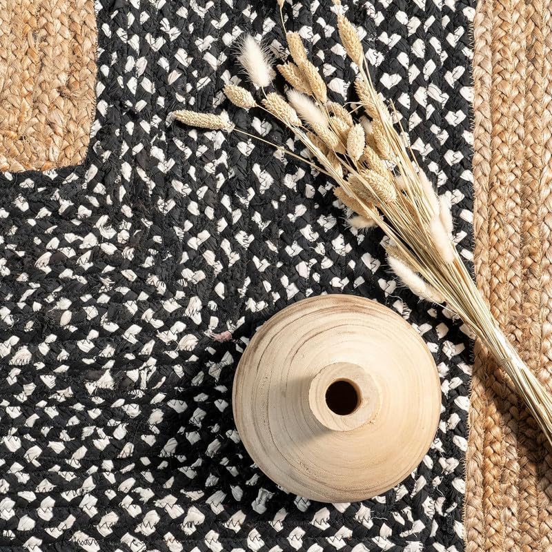 Black and white patterned fabric with a wooden spool and dried plants on top