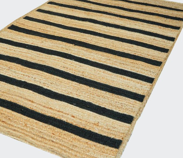 Striped rug with black and beige stripes on a white background