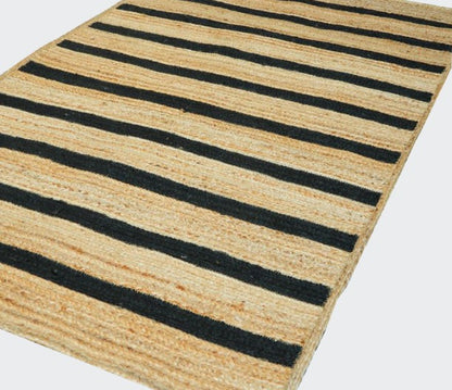 Striped rug with black and beige stripes on a white background