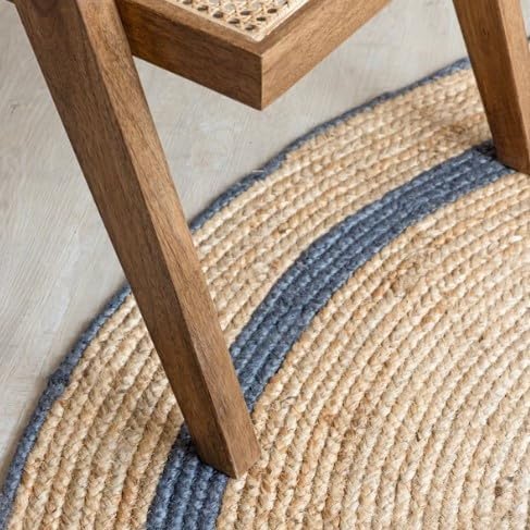 Natural wood chair with woven cane seat, featuring a modern design and placed on a round jute rug.