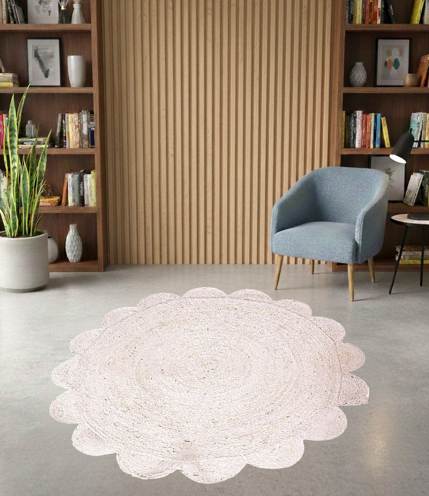 White round rug on a gray floor with a blue chair and bookshelves in the background.