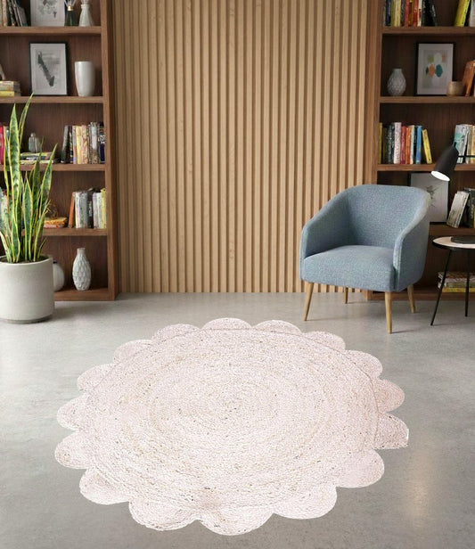 White round rug on a gray floor with a blue chair and bookshelves in the background.