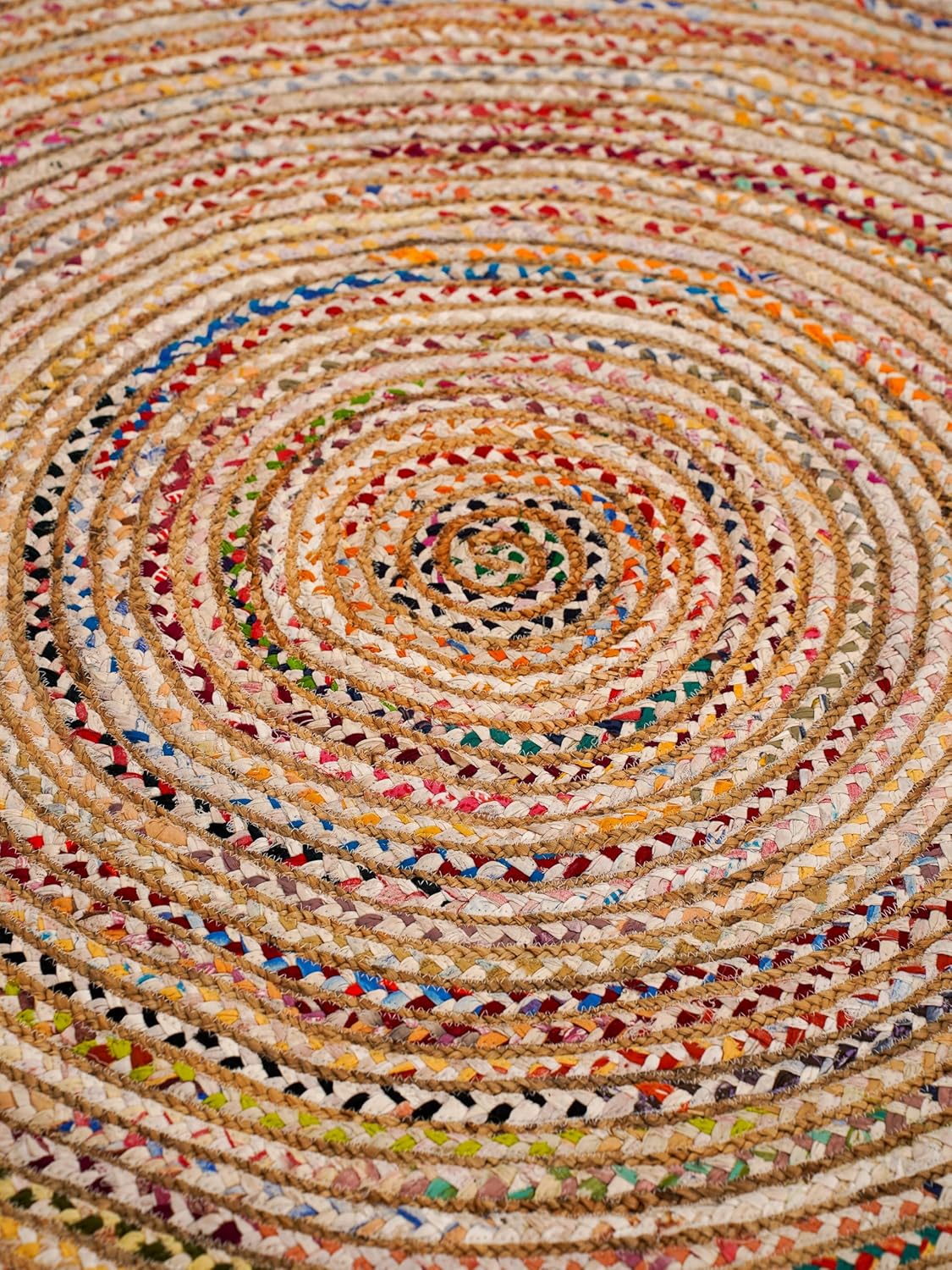 Colorful braided round rug, made of natural fibers, featuring vibrant spirals and a textured design.